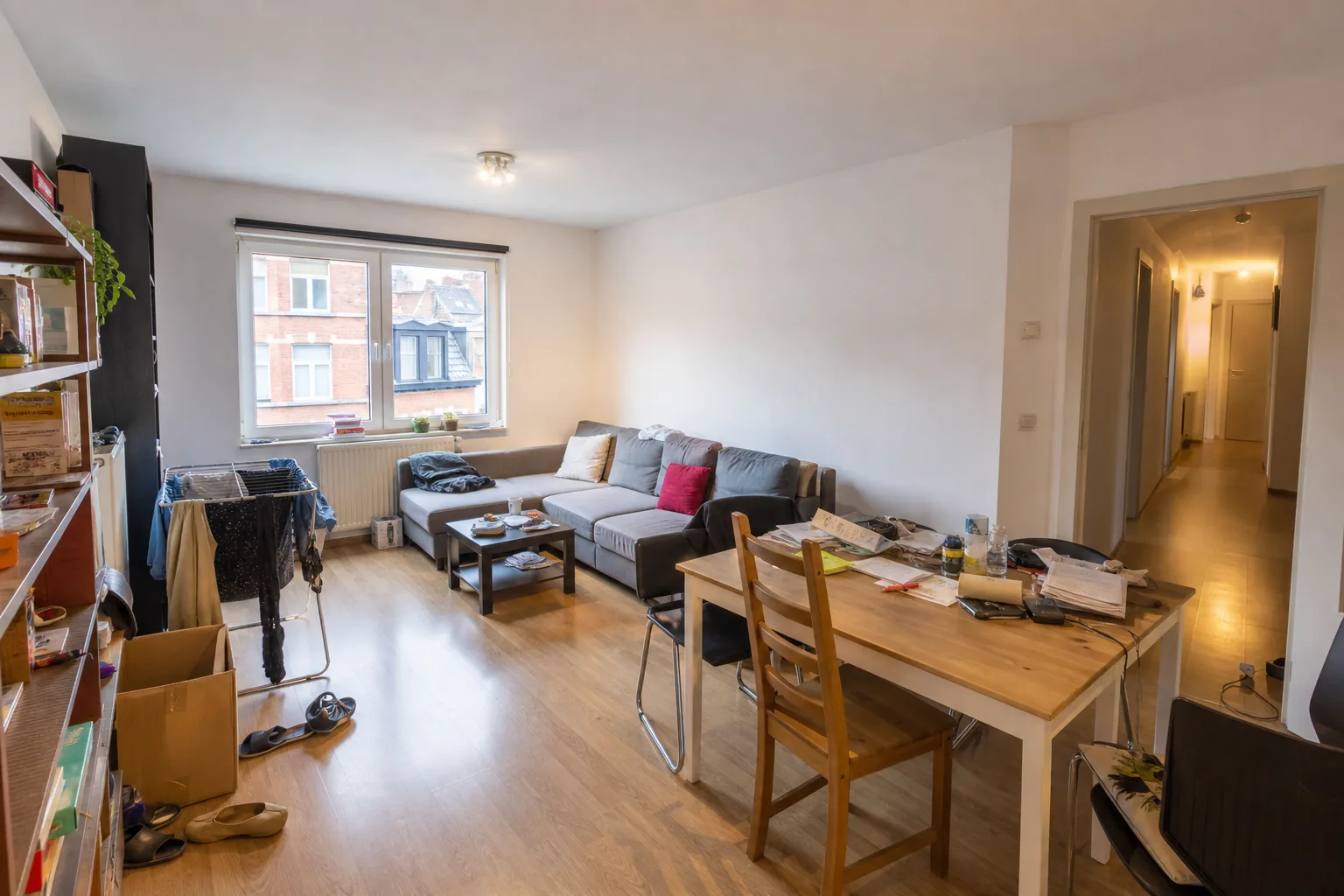 Cluttered living room in an occupied Belgian apartment, photographed as-is